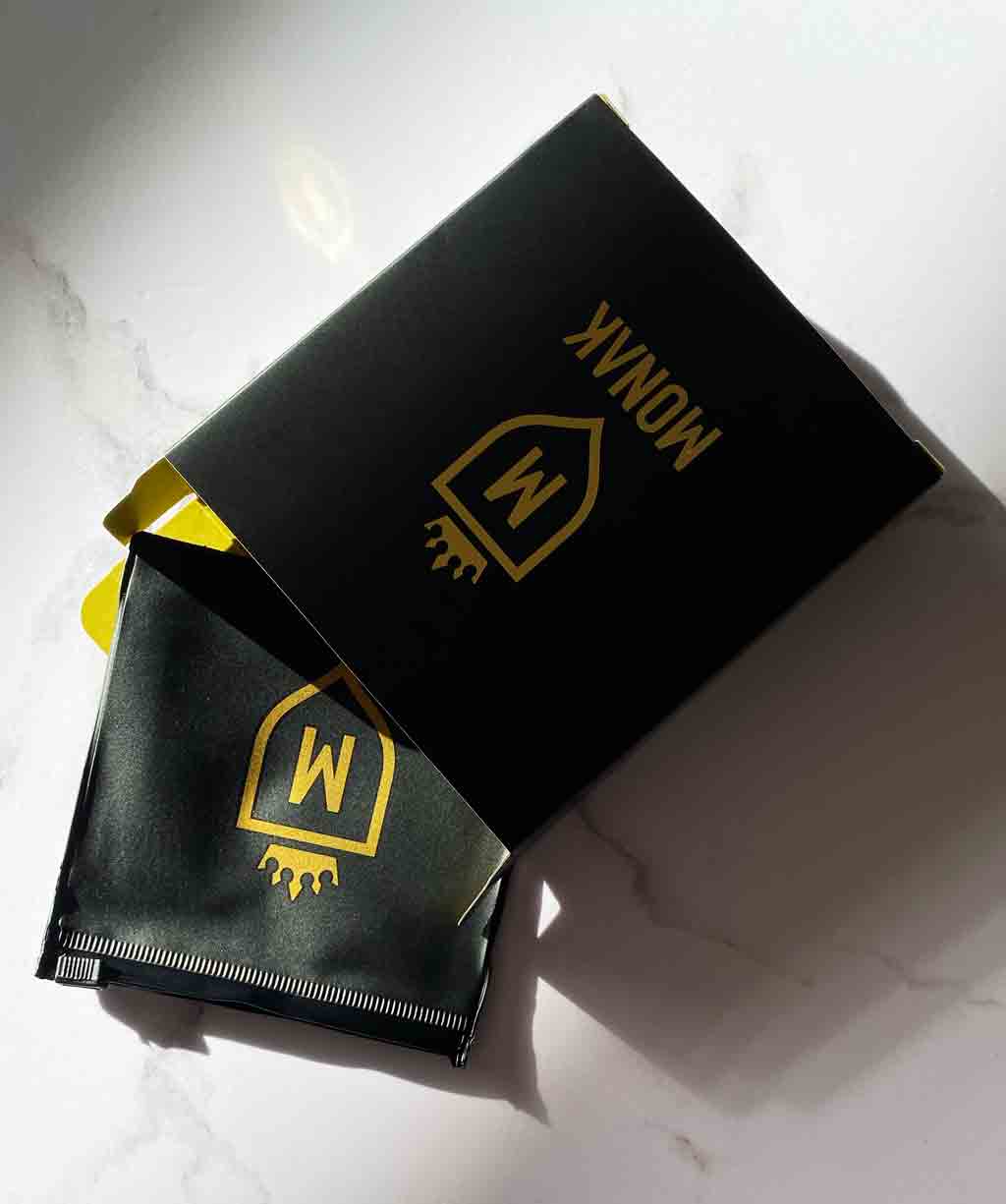 Packaging MONAK: caja negra de regalo con el sello de la marca